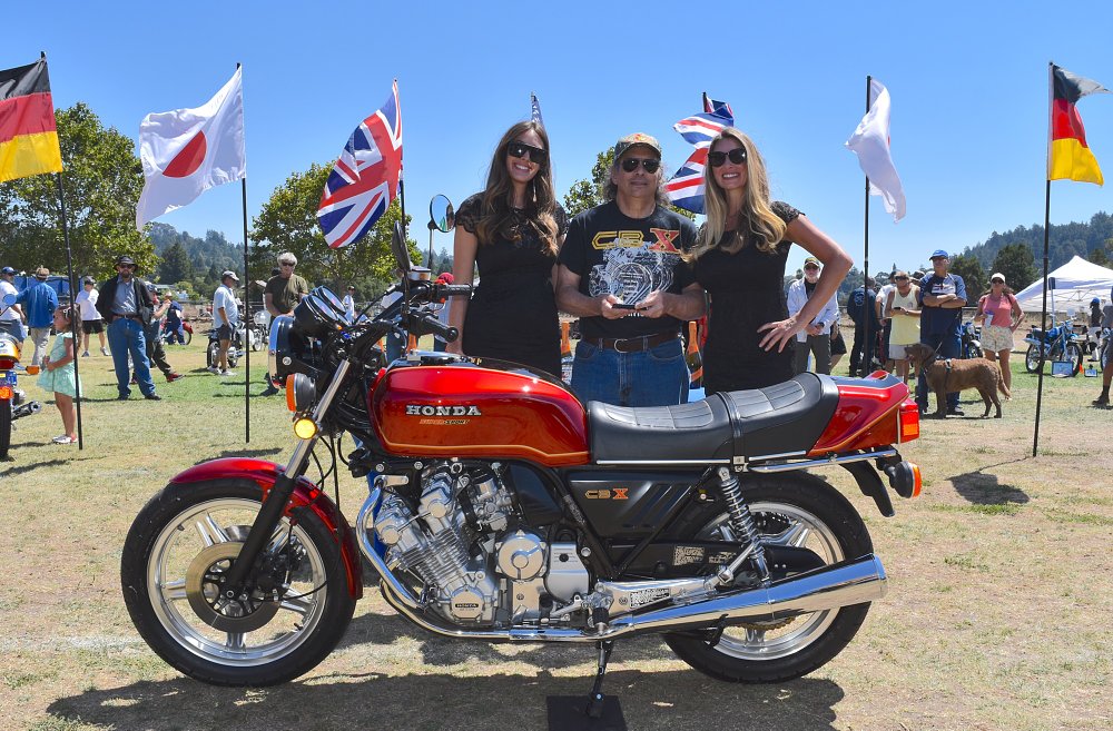 photo of Catelani holding a trophy and standing behind his red CBX