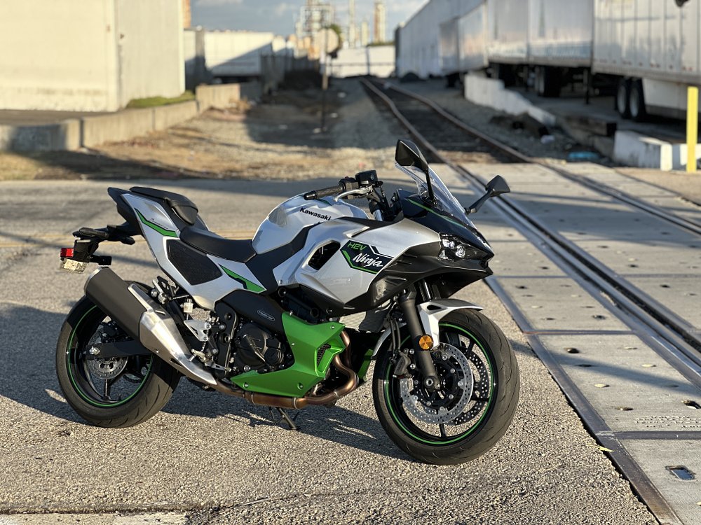 2025 Kawasaki Ninja 7 Hybrid parked near railroad tracks.