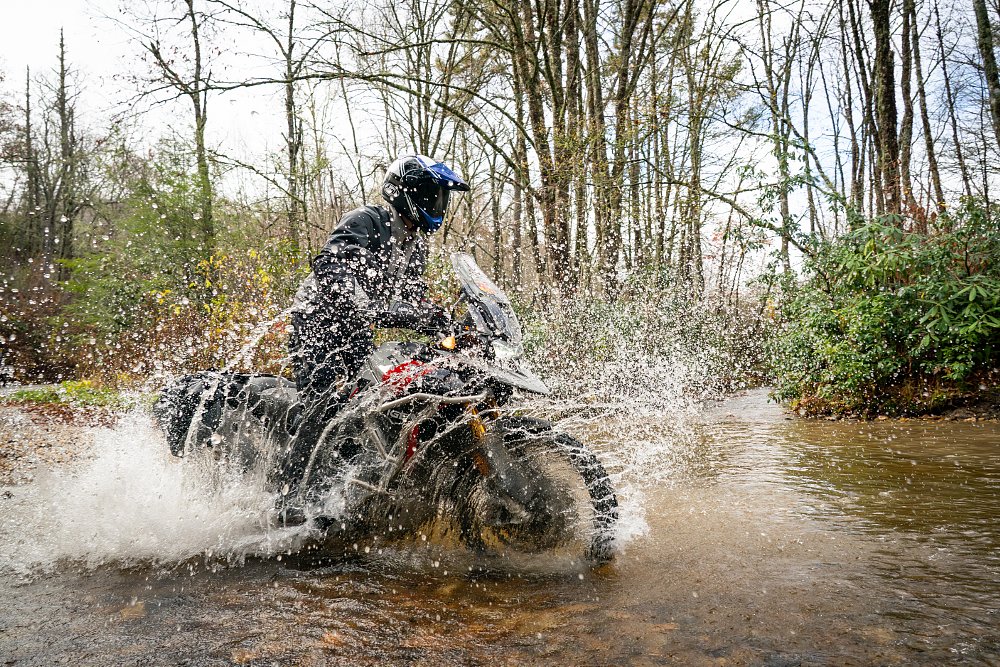 Dustin blasting through a water crossing on the Triumph Tiger 900 Rally Pro.