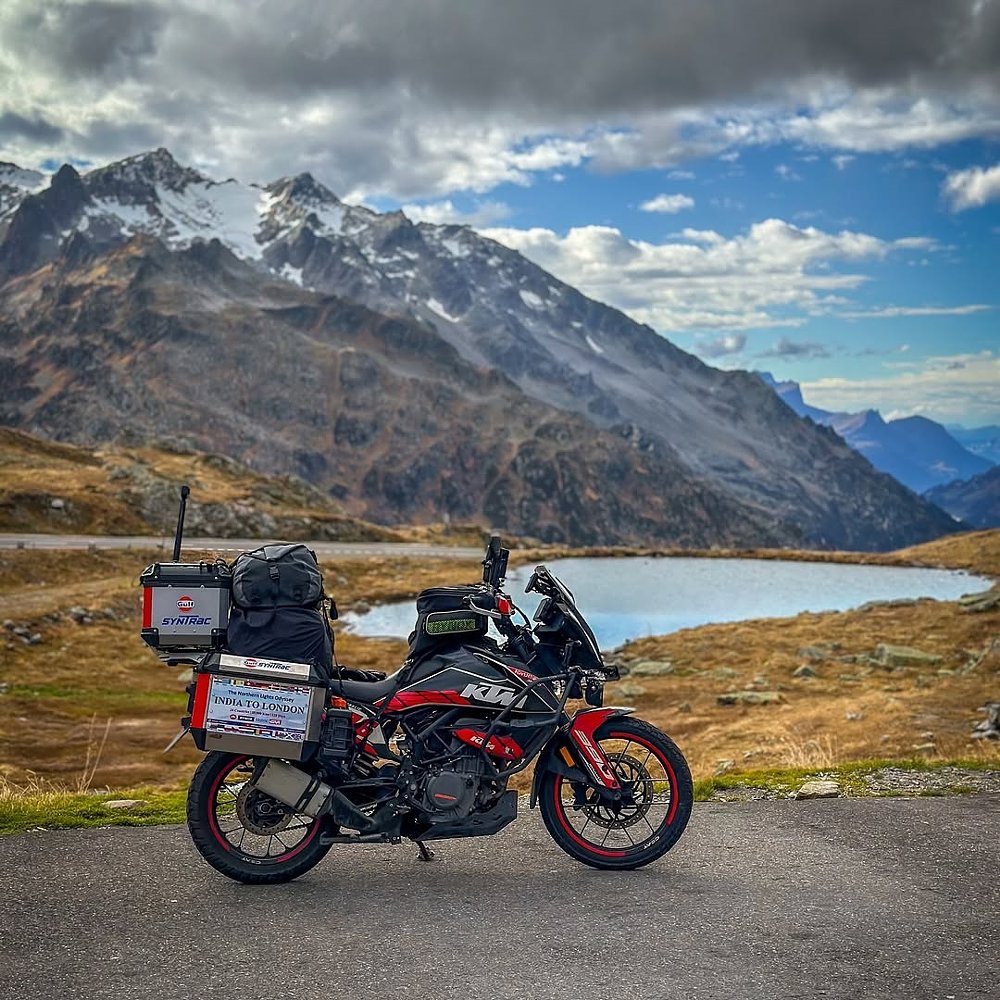 the fully loaded KTM parked by a mountain lake