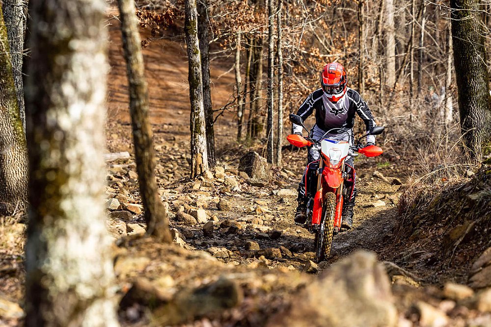 A Honda CRF300L rider picks through rocks on an uphill trail.