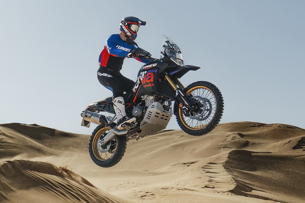 A rider launches the Aprilia Tuareg Rally 660 over a sand dune.