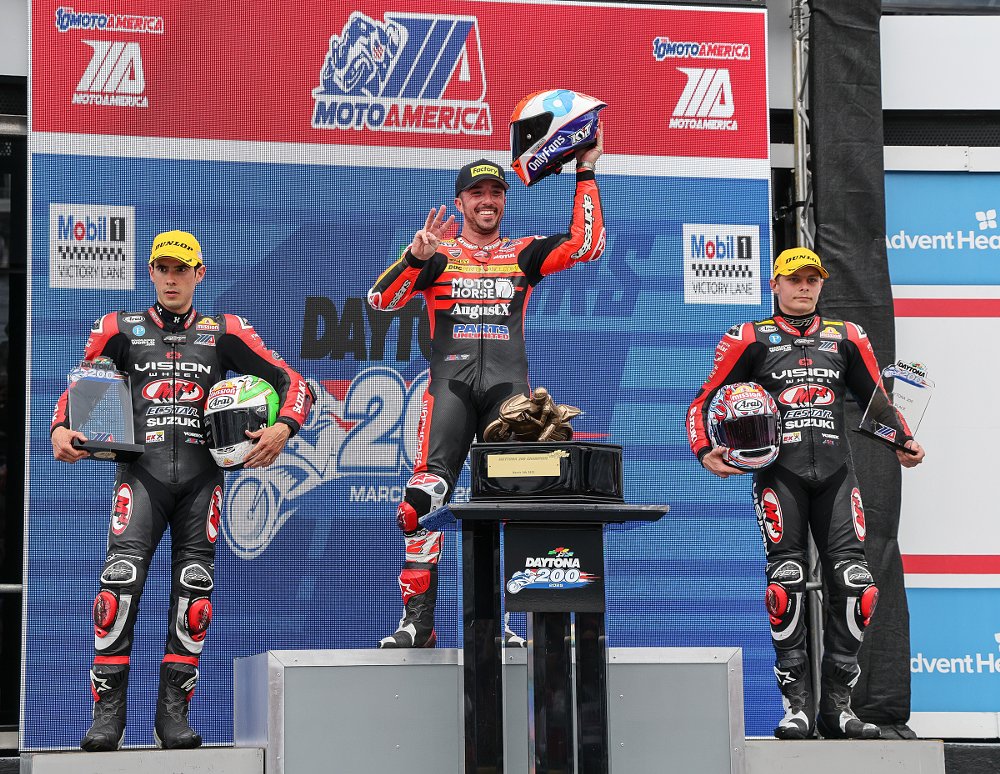 riders on the Daytona 200 podium with Herrin smiling and Escalante and Scott expressionless