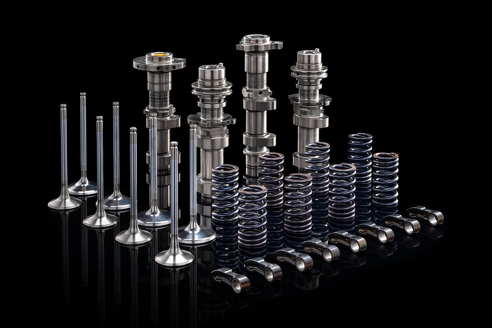 Individual components of the Streetfighter V2's spring valvetrain lined up within a black background.