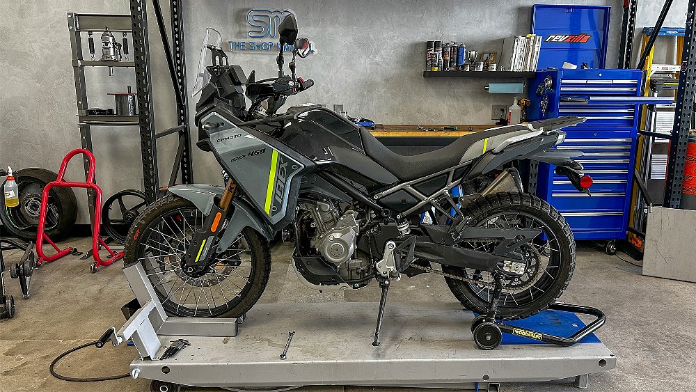 Dustin's CFMOTO Ibex 450 long-term review unit stands on the RevZilla West garage lift.