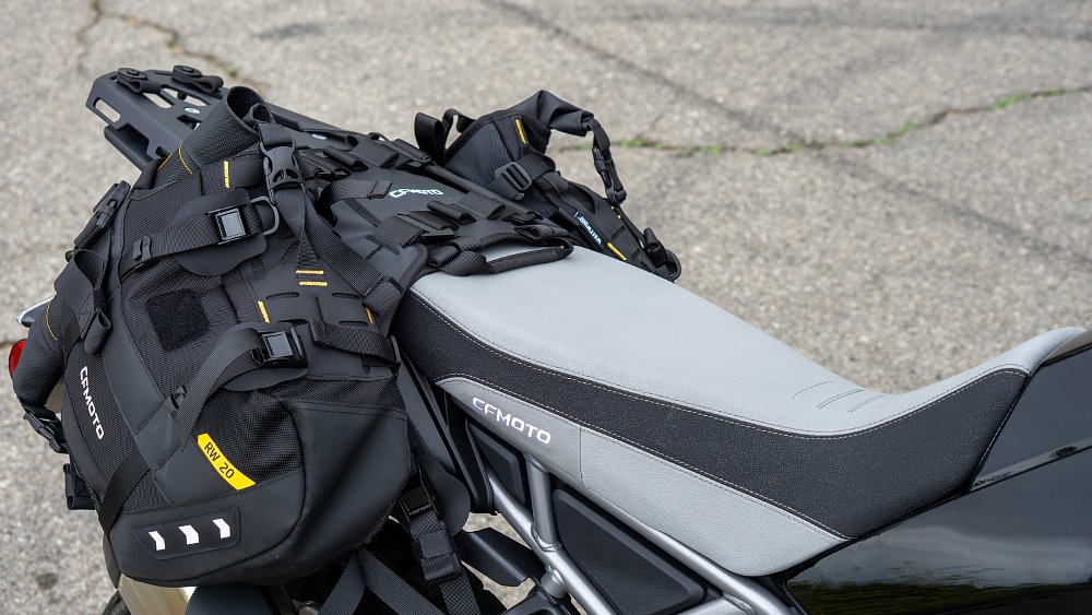 The CFMOTO Ibex 450 project bike's tall rally seat and 40-liter soft bags shot from the motorcycle's right side.