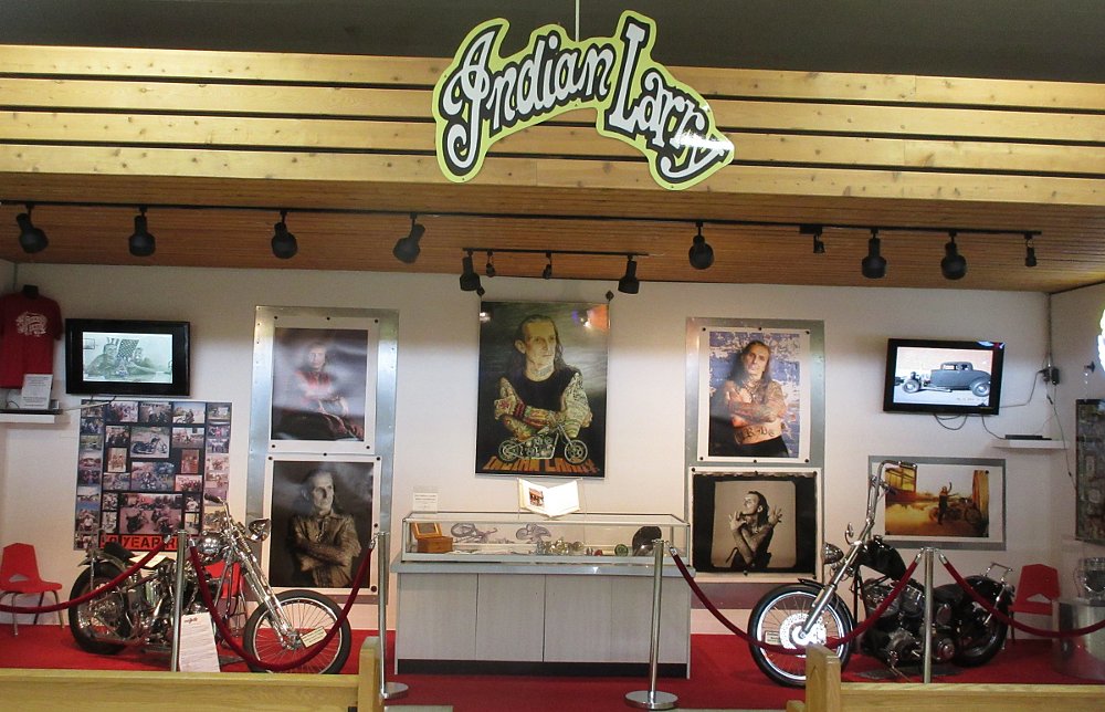 area with two choppers on display and several photographs of Indian Larry