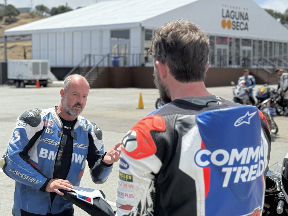 California Superbike School coach talks to a student in the paddock of Laguna Seca Raceway.