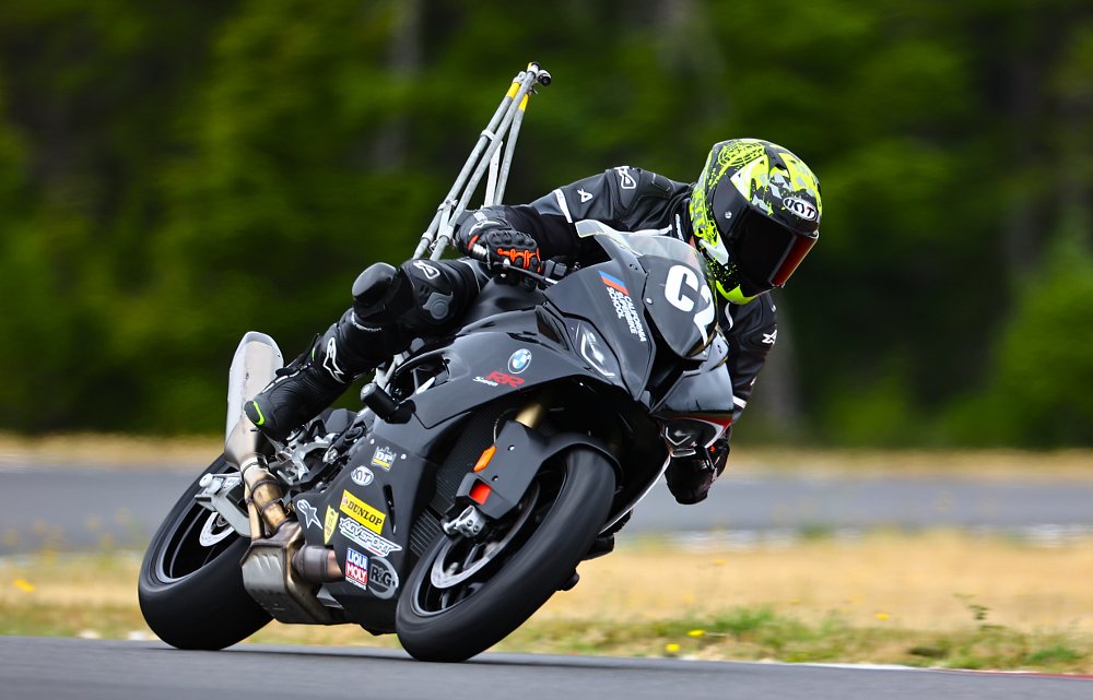 A BMW S 1000 RR riding around a track with a camera mounted to its tail section.