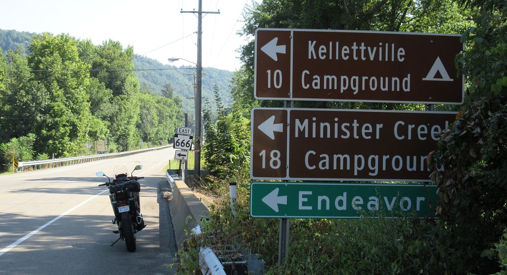 Transalp parked by signs pointing to Route 666 and Ministers Creek Campground
