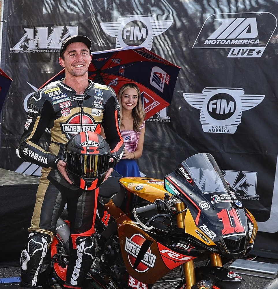 smiling Mathew Scholtz at a podium celebration after finishing third in a Superbike race for the Westby team