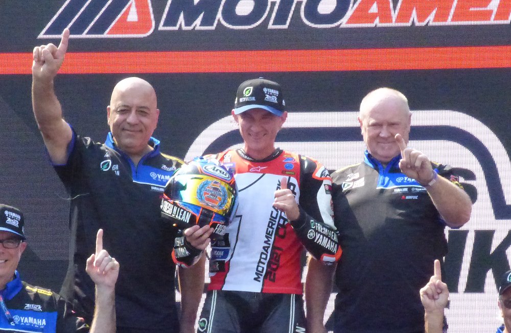 Stanboli, Gagne, and Cornwell holding up 'number one' fingers and celebrating Gagne's championship in 2021