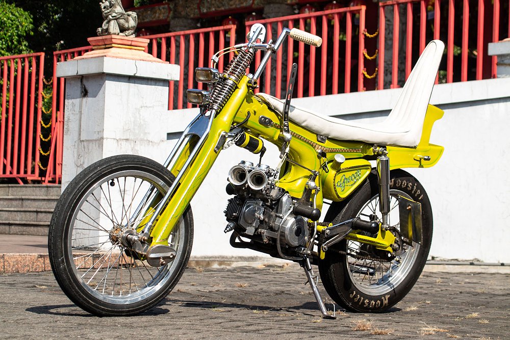 yellow customized Honda scooter with tall white seat