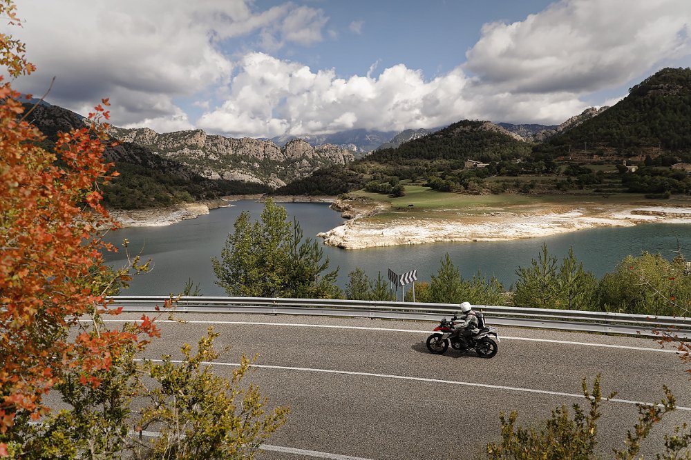 overhead view of the BMW on a curvy road in Andorra with a lake and mountains in the background