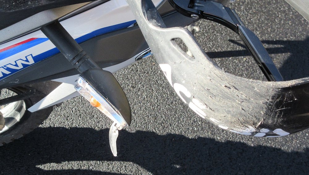 close view of shattered turn signal lens and heavily scratched handguard on the G 310 GS