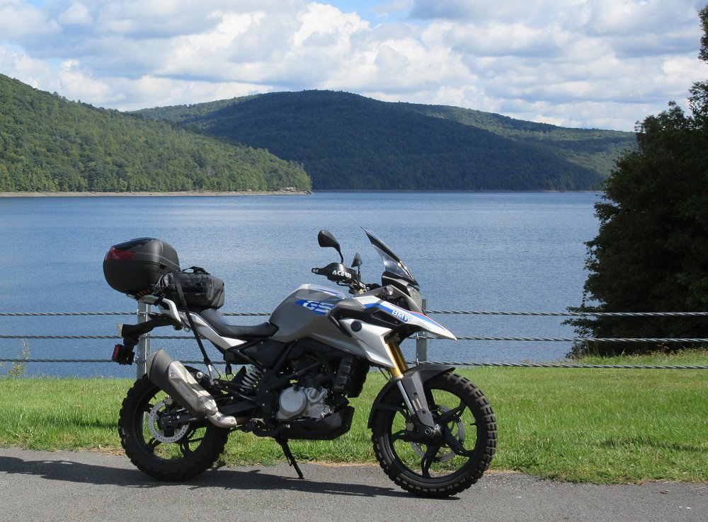 the G 310 GS parked at an overlook above a reservoir surrounded by forests