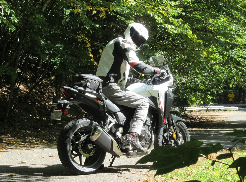 rider on the NX500 on a country gravel road looking back at the camera