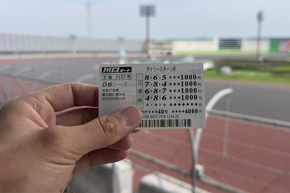 Dustin holds up his auto race betting stub with the Kawaguchi Auto Race Circuit in the background.