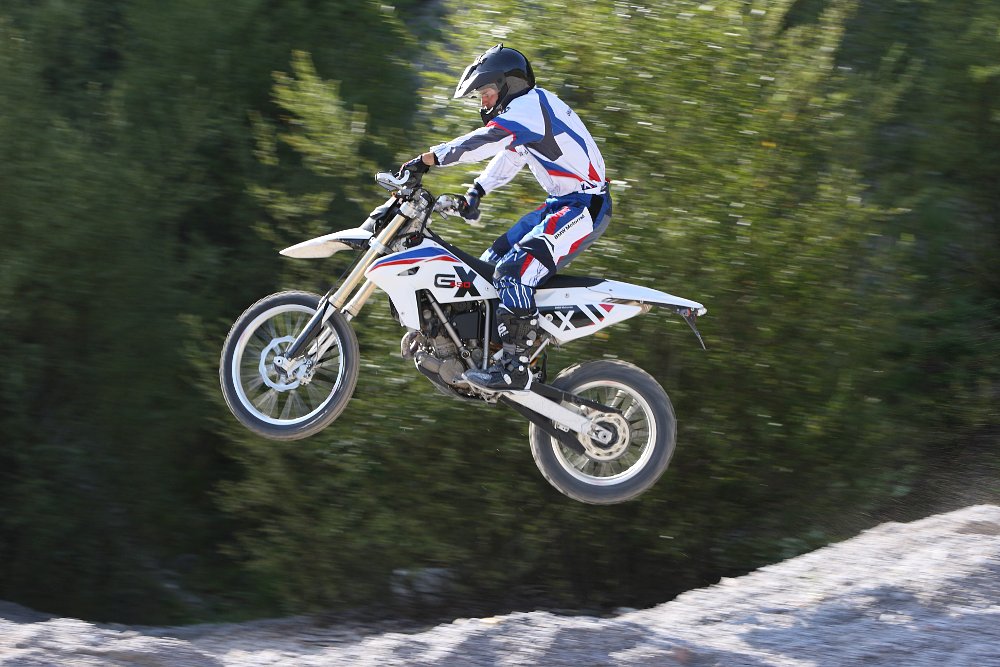 2009 BMW G 450 X off-road motorcycle jumping over a dirt pile.