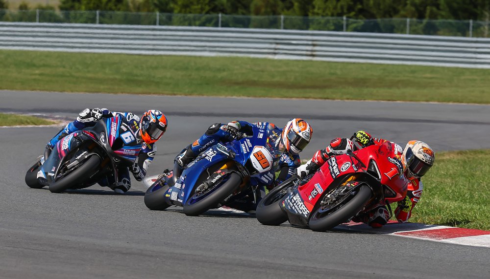 the three MotoAmerica Superbike title contenders racing nose to tail through a curve at NJMP