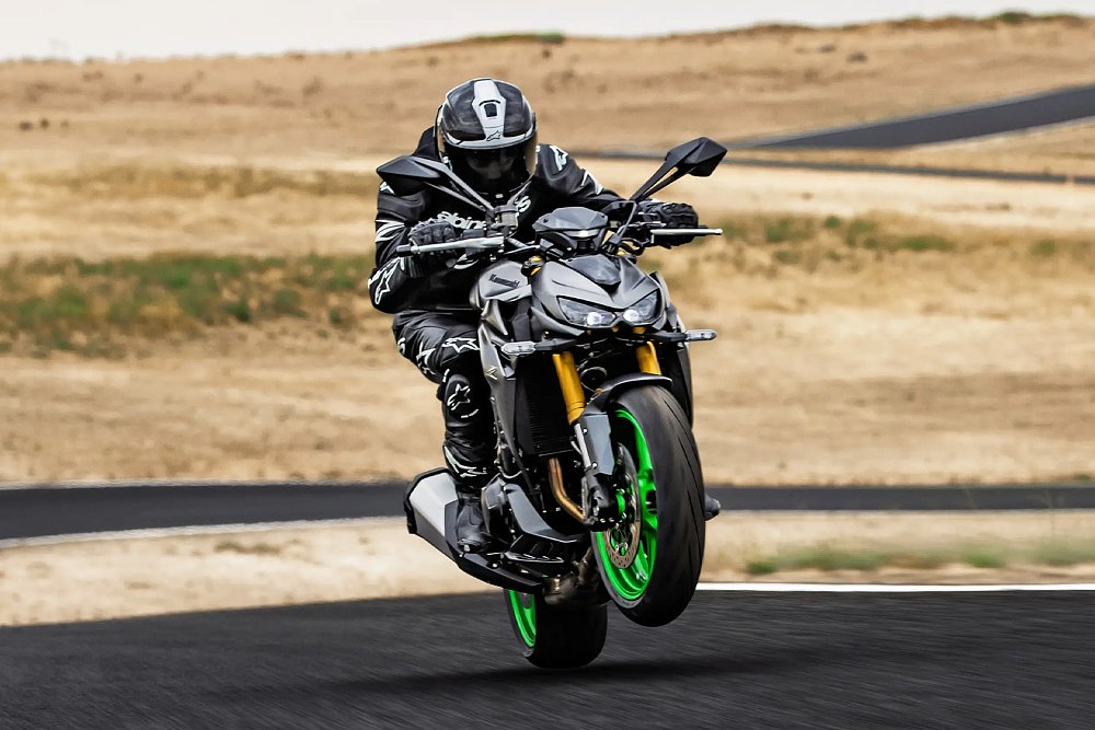 A Kawasaki Z1100 rider wheelies on the race track.