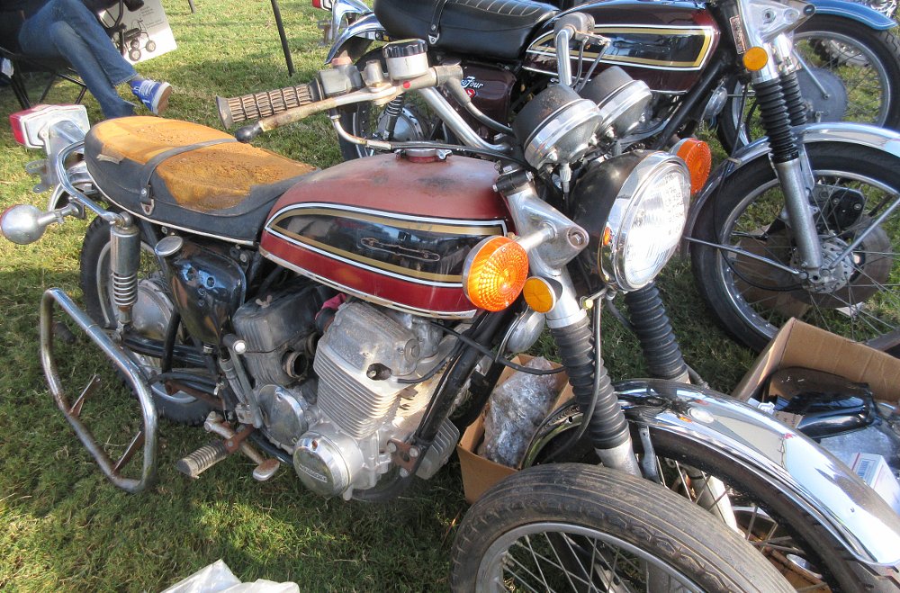old Honda CB750 with rusty parts, missing exhaust, torn seat