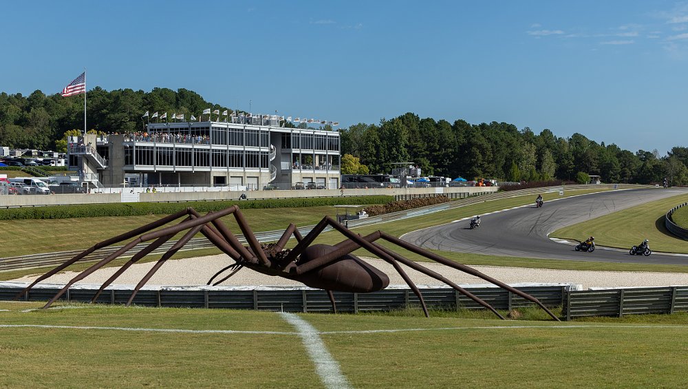 huge spider sculpture sits inside a turn of the race track