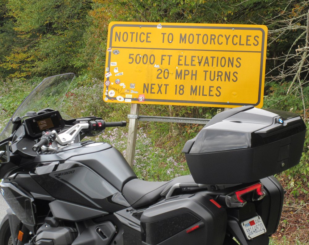 RT parked in front of a sign warning motorcycles of curves ahead