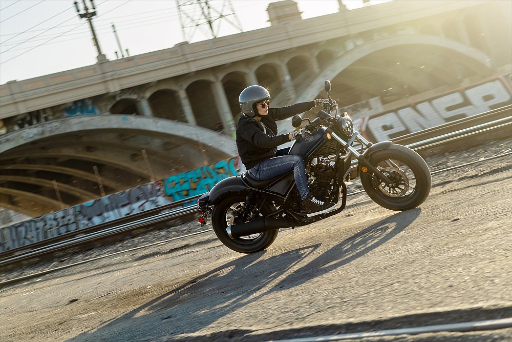 A Rebel 300 E-Clutch rider pictured near bridge and train tracks.